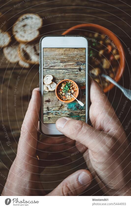 Man's hand taking picture of Mediterranean soup in bowl, close-up Stew Hot Pot Smartphone iPhone Smartphones photographing human hand hands human hands men