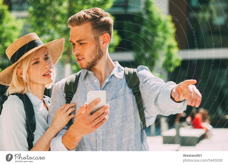 Two tourist orientating with smartphone couple twosomes partnership couples Smartphone iPhone Smartphones people persons human being humans human beings