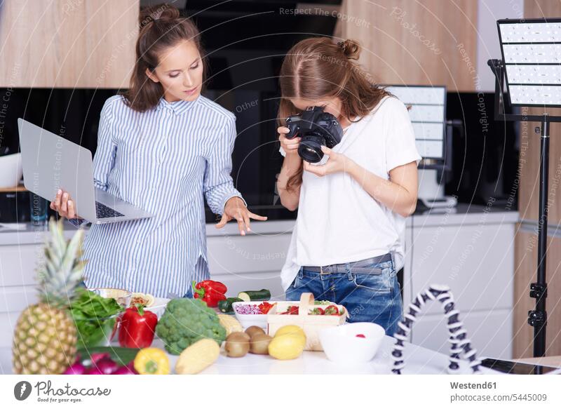 Woman photographing food in kitchen computers Laptop Computer Laptop Computers laptops notebook cameras domestic kitchen kitchens human human being human beings
