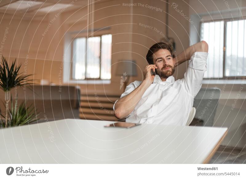 Portrait of young freelancer on the phone in a loft call telephoning On The Telephone calling telephone call Phone Call using phone Using Phones freelancing