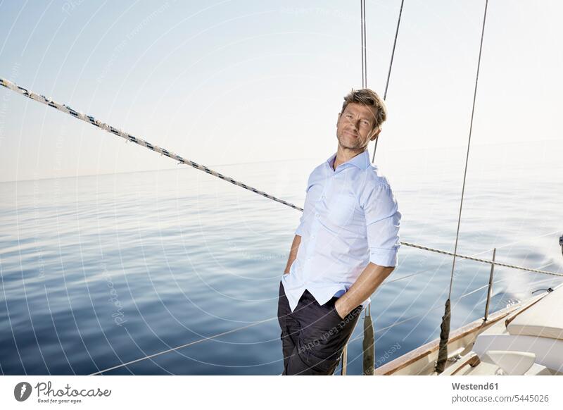 Portrait of smiling mature man standing on his sailing boat portrait portraits men males boat sports Adults grown-ups grownups adult people persons human being