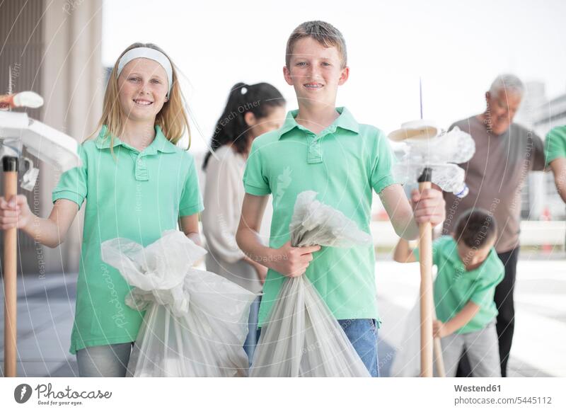 Group of volunteering children collecting garbage with litter sticks collected Litter Bag student pupils waste trash bags schoolchildren education togetherness