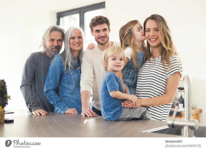 Happy family with grandparents and children standing in the kitchen Family reunion domestic kitchen kitchens families happiness happy together people persons