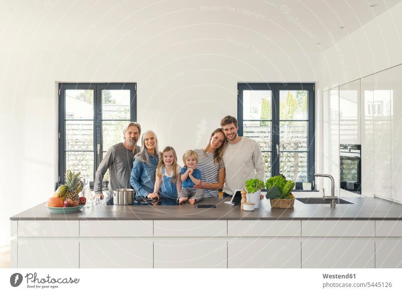 Happy family with grandparents and children standing in the kitchen cooking happiness happy recipe recipes Family reunion families together domestic kitchen