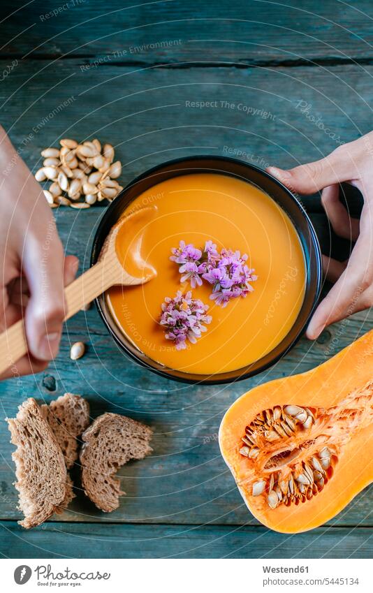 Close-up of man's hands eating creamed pumpkin soup spoon spoons Soup Soups Potage human hand human hands Pumpkin Soups wooden spoon wooden spoons Food foods