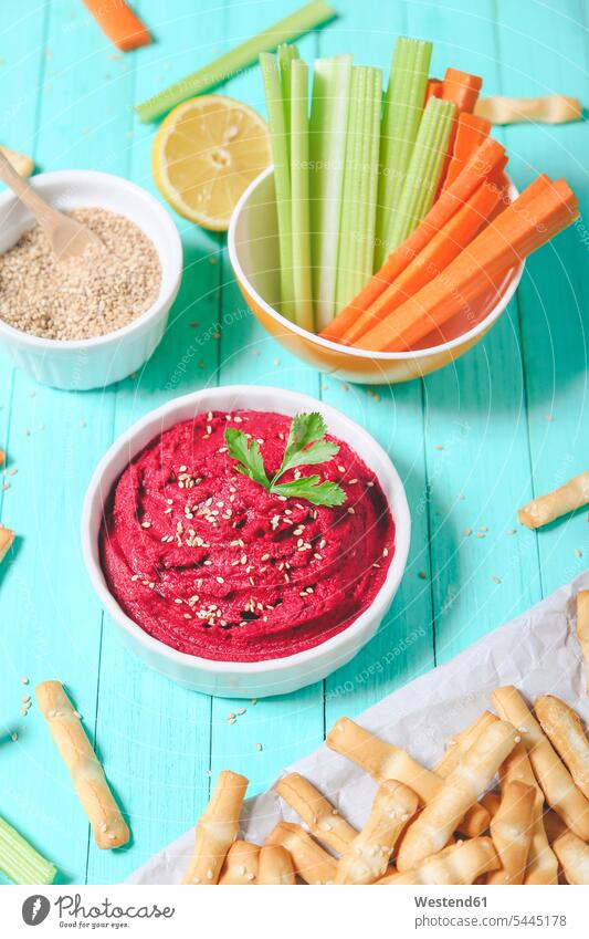 Bowl of beetroot hummus, sesame, carrot and celery crudites and breadsticks wooden spoon wooden spoons Hummus sesame seeds Carrot Carrots dip dips mashed puréed