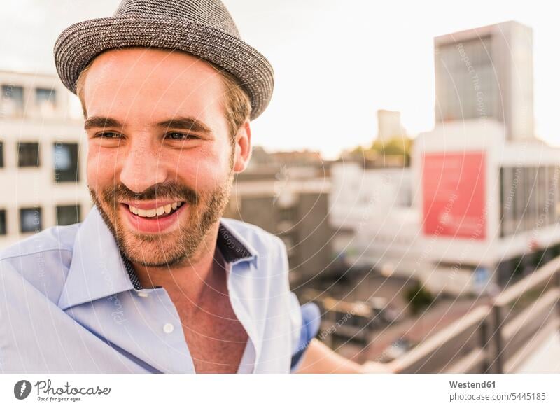 Portrait of happy young man on rooftop roof terrace deck men males portrait portraits smiling smile Adults grown-ups grownups adult people persons human being