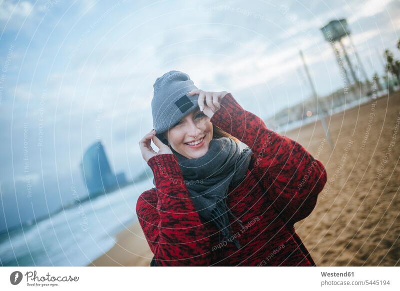 Portrait of smiling young woman on the beach in winter smile beaches females women happiness happy Adults grown-ups grownups adult people persons human being