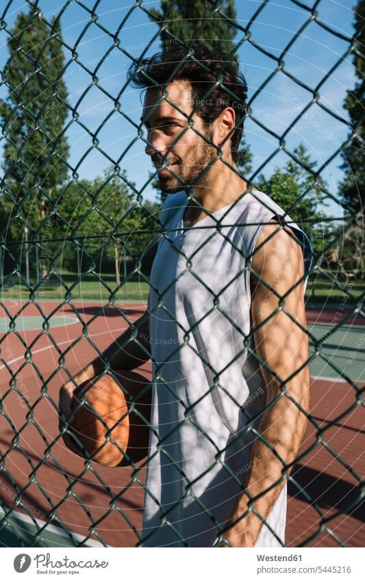 Man with basketball behind wire mesh fence Wire Mesh Fence Chainlink Fence Chain Link Fence Chain-link Fence Chainlinked Fence Mesh Wire Fence Chainlink Fences