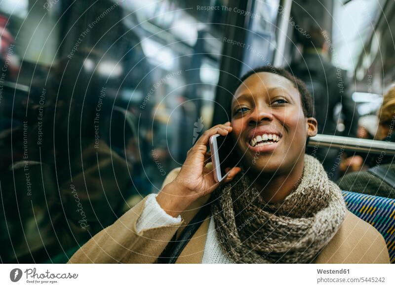 Portrait of smiling young woman on the phone in underground train females women portrait portraits call telephoning On The Telephone calling Adults grown-ups