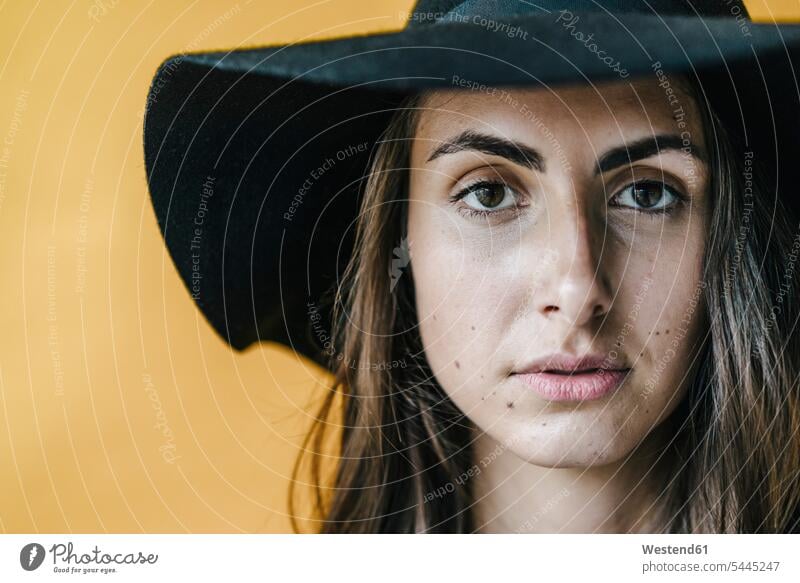 Portrait of brunette young woman wearing a floppy hat hats portrait portraits brown hair brown haired brown-haired females women dark hair dark-haired people