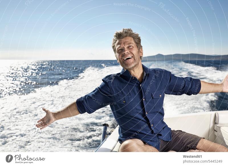 Portrait of happy mature man on his motor yacht men males motor yachts portrait portraits Adults grown-ups grownups adult people persons human being humans