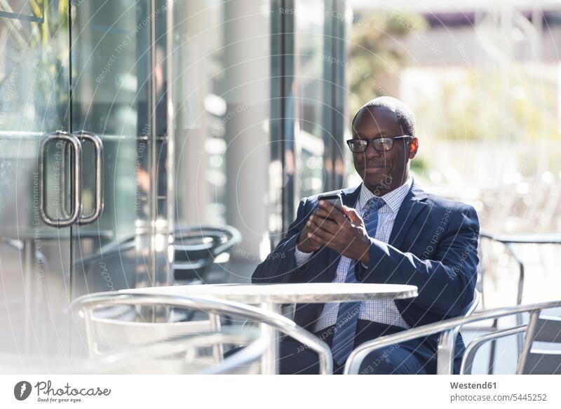 Businessman using cell phone at outdoor cafe break mobile phone mobiles mobile phones Cellphone cell phones Business man Businessmen Business men telephones