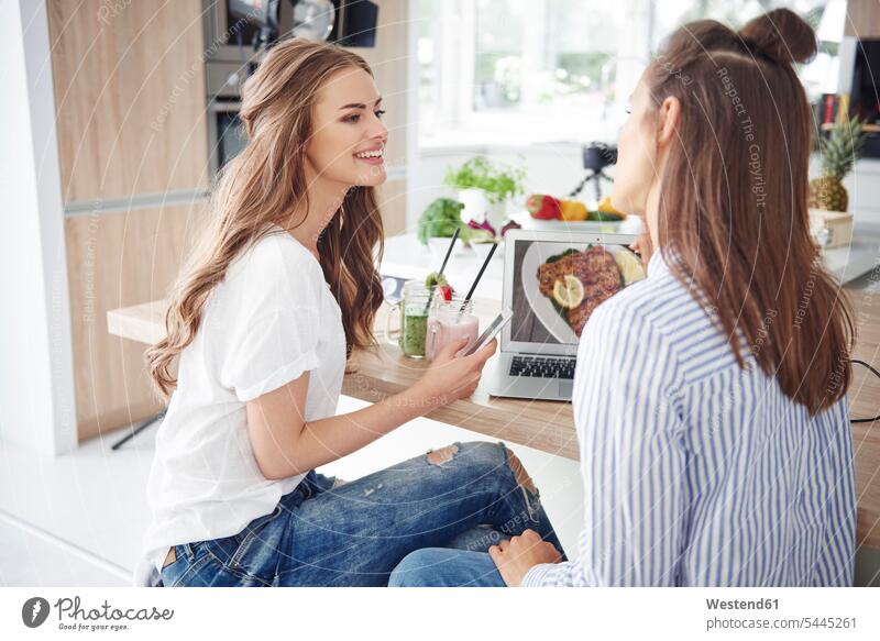 Bloggers talking in kitchen computers Laptop Computer Laptop Computers laptops notebook smile domestic kitchen kitchens Alimentation food Food and Drinks
