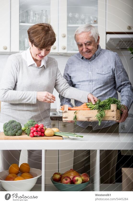 Senior couple standing in kitchen, unpacking fresh vegetables caucasian caucasian ethnicity caucasian appearance european Vegetable Vegetables together bonding
