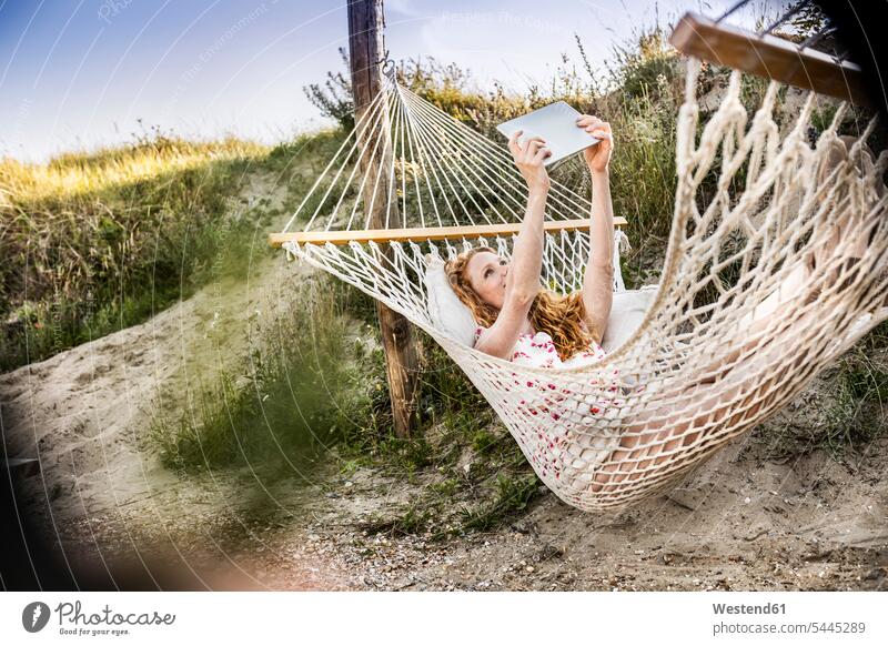 Woman lying in hammock taking a selfie with tablet relaxed relaxation digitizer Tablet Computer Tablet PC Tablet Computers iPad Digital Tablet digital tablets