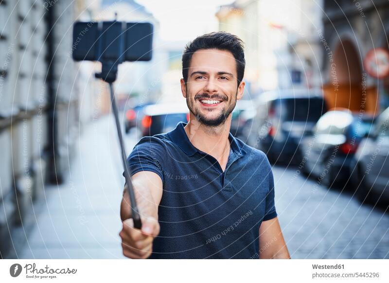 Man taking photo with smartphone mounted on selfie stick man men males happiness happy Selfie Selfies smiling smile mobile phone mobiles mobile phones Cellphone
