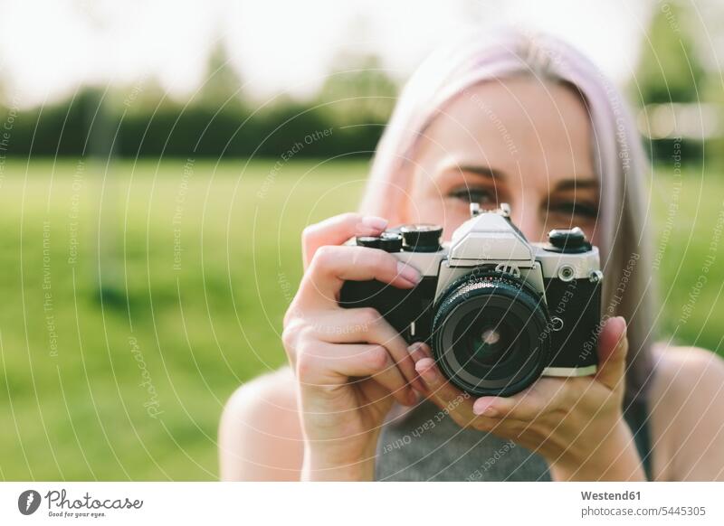 Young woman taking pictures with camera in nature portrait portraits photographing females women Adults grown-ups grownups adult people persons human being