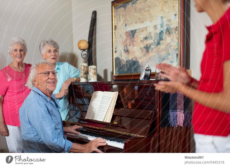 Elderly people making music in retirement home piano pianos nursing home laughing Laughter playing music make music play music senior adults seniors old