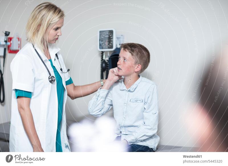 Female pedeatrician examining boy with an otoscope stethoscope pediatrician paediatricians listening boys males healthcare and medicine medical