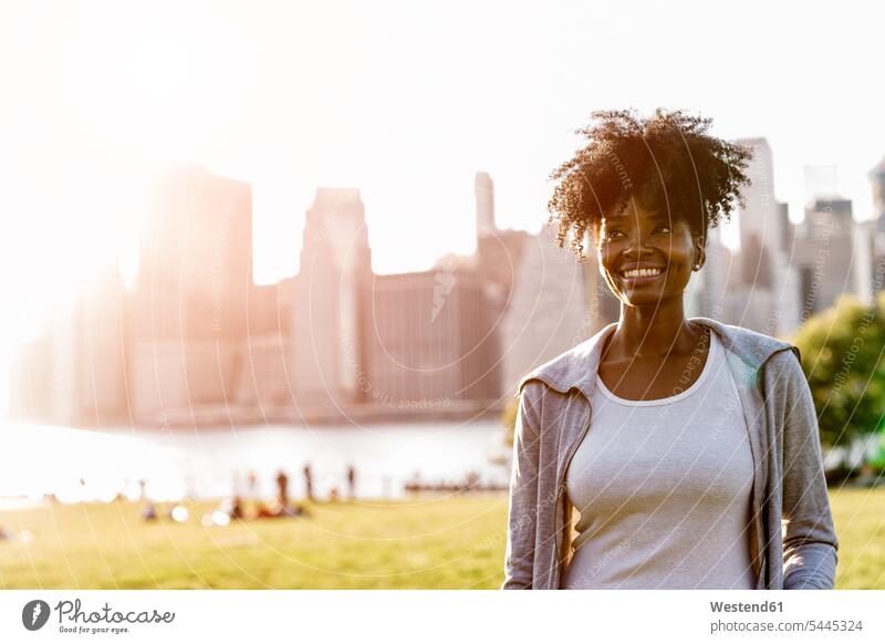 USA, New York City, Brooklyn, smiling woman standing on a meadow smile females women Adults grown-ups grownups adult people persons human being humans