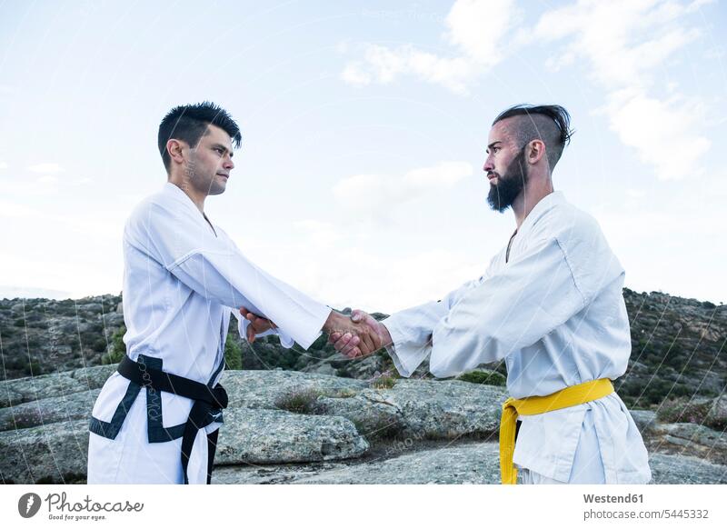 Men shaking hands during a martial arts training exercising exercise practising Handclasp Handclap man men males fighting combative sport handshake Adults