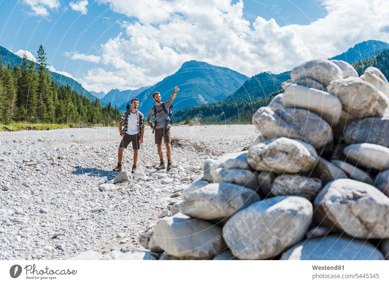 Germany, Bavaria, two hikers standing in dry creek bed looking at view friends wanderers friendship hiking explaining watching river bed riverbed hiking tour