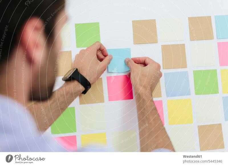Young businessman working in office with sticky notes on wall Adhesive Note post-it note adhesive notes Adhesive Notes Businessman Business man Businessmen