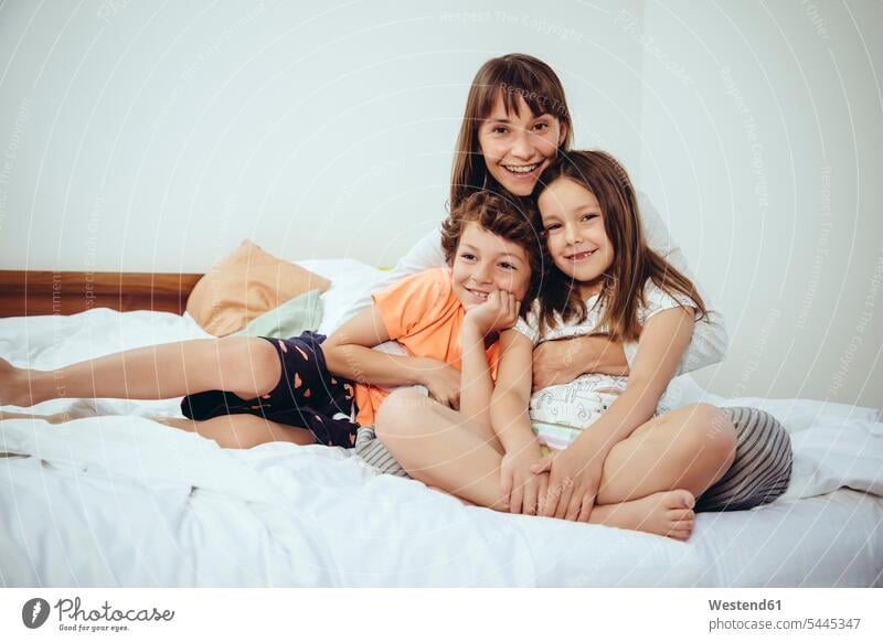 Happy mother in bed with her daughter and son family families portrait portraits mommy mothers ma mummy mama beds smiling smile people persons human being