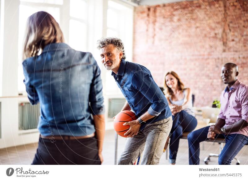 Colleagues playing basketball in office colleagues offices office room office rooms Basketball workplace work place place of work sport sports together