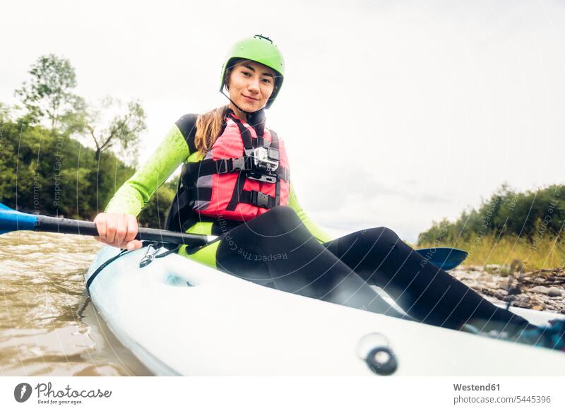 Germany, Bavaria, Allgaeu, portait of confident young woman kayaking on river Iller River Rivers canoe females women portrait portraits water waters