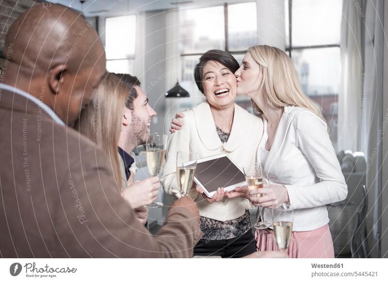 Happy woman showing tablet to friends with champagne glasses at home Sparkling Wine celebrating celebrate partying digitizer Tablet Computer Tablet PC