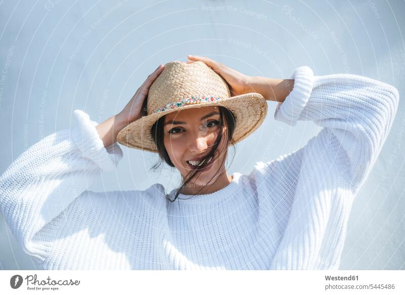 Portrait of laughing young woman wearing straw hat portrait portraits females women straw hats Laughter Adults grown-ups grownups adult people persons