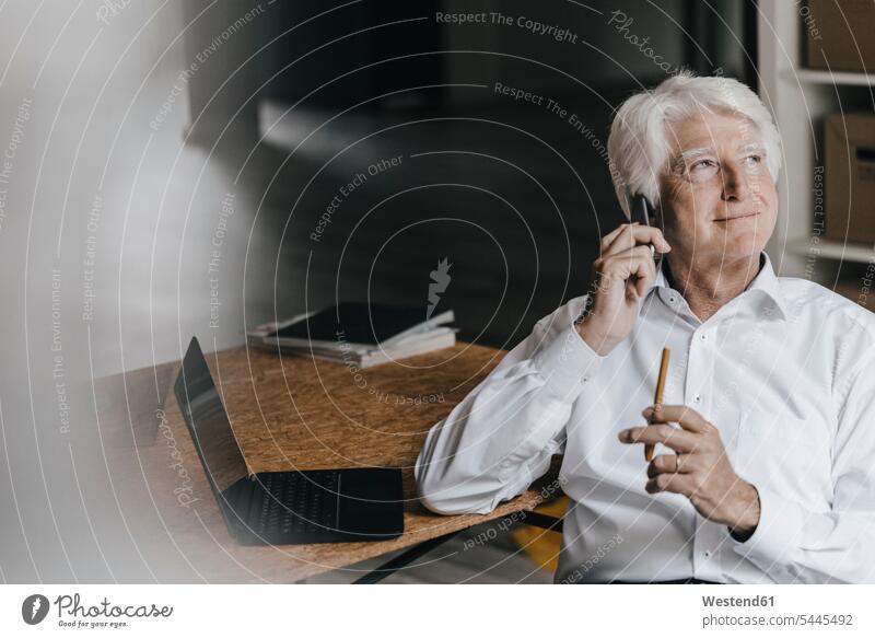 Portrait of smiling senior businessman on the phone in his office Businessman Business man Businessmen Business men offices office room office rooms call