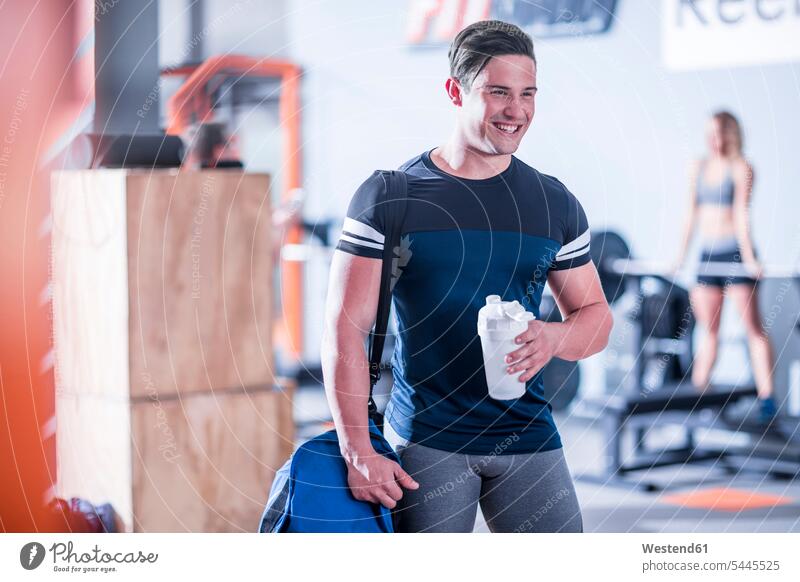 Smiling young man in gym break exercising exercise training practising gyms Health Club smiling smile men males fitness sport sports Adults grown-ups grownups