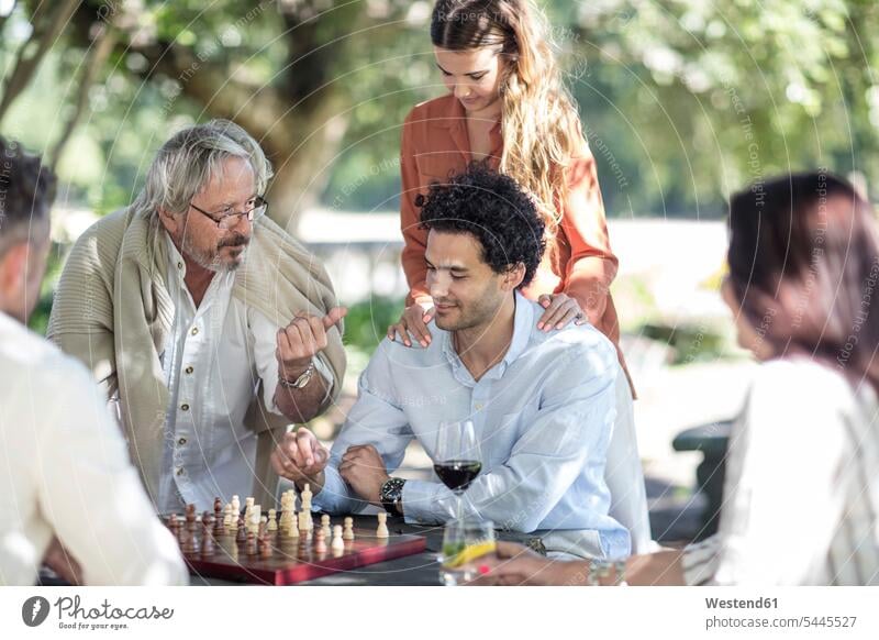 People gathering around chess board man men males advising counseling advise playing Adults grown-ups grownups adult people persons human being humans