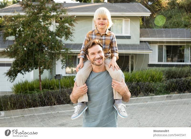 Portrait of boy on father's shoulders in front of their home house houses carrying portrait portraits pa fathers daddy dads papa boys males son sons manchild