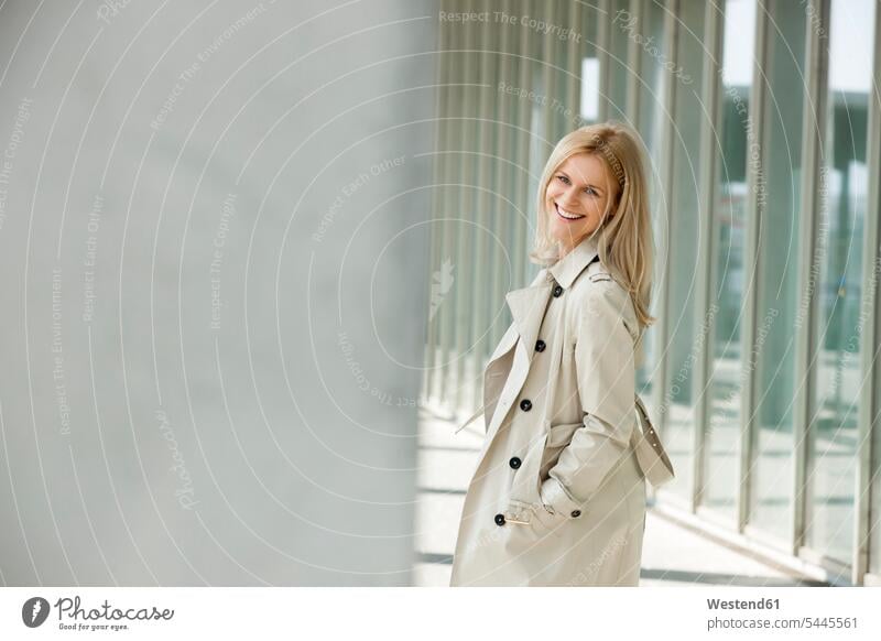 Portrait of smiling blond woman wearing trench coat females women trenchcoat portrait portraits Adults grown-ups grownups adult people persons human being