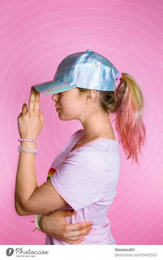 Stylish young woman with dyed hair wearing basecap in front of pink background females women Adults grown-ups grownups adult people persons human being humans