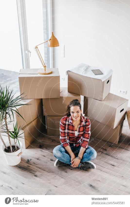 Mature woman moving house, sitting on floor, thinking floors property females women cross-legged tailor seat flat flats apartment apartments owner owners move