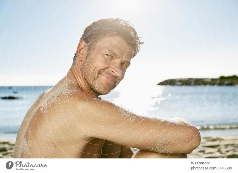 Portrait of smiling man relaxing on the beach Sea ocean portrait portraits men males beaches water Adults grown-ups grownups adult people persons human being
