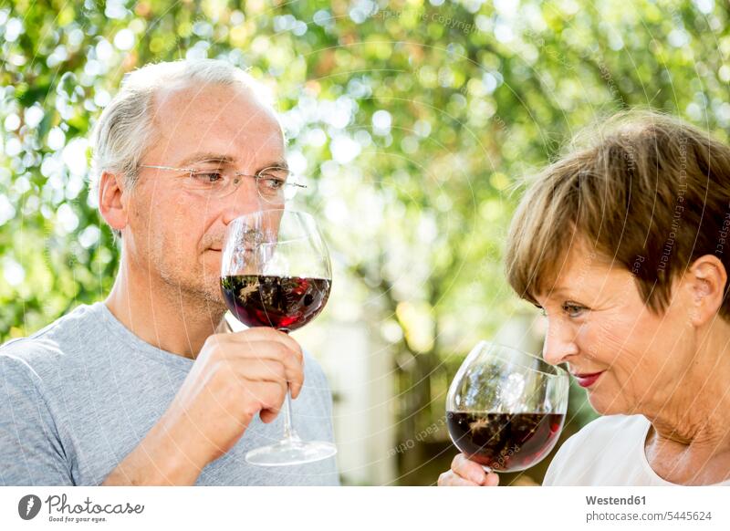Senior couple having glass of red wine outdoors smelling twosomes partnership couples Wine people persons human being humans human beings Alcohol
