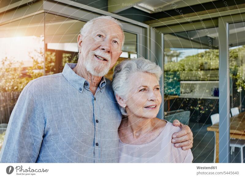 Senior couple standing in front of their house, looking confident married couple married couples happiness happy terrace terraces senior adults seniors old