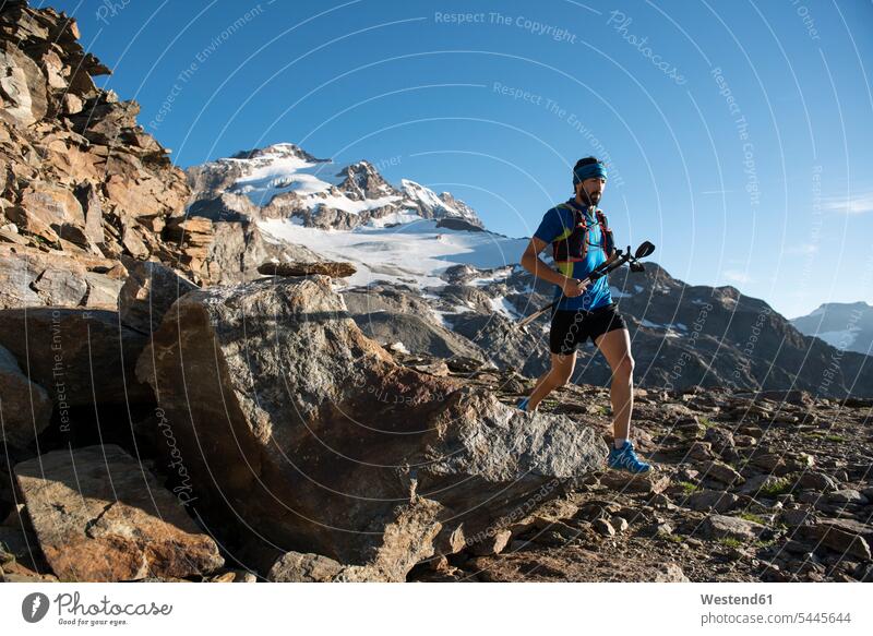 Italy, Alagna, trail runner on the move near Monte Rosa mountain massif athlete Sportspeople Sportsman Sportsperson athletes Sportsmen mountains running males