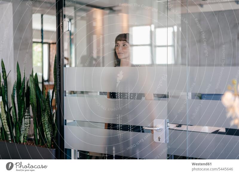 Businesswoman standing behind glass door Success successful excluded spying Office Offices businesswoman businesswomen business woman business women Solitude