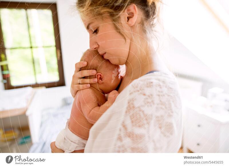 Mother holding little baby at home infants nurselings babies cuddling snuggle cuddle snuggling mother mommy mothers ma mummy mama consoling console comforting