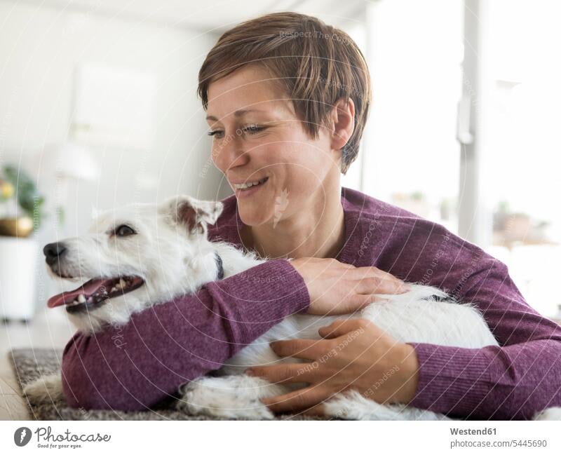 Woman hugging her dog at home dogs Canine woman females women pets animal creatures animals Adults grown-ups grownups adult people persons human being humans
