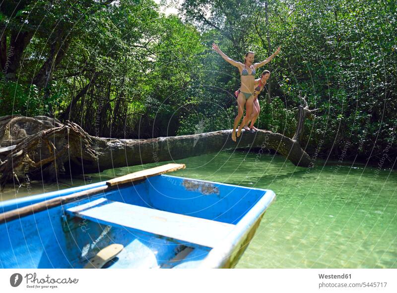 Dominican Republic, Samana, two women jumping into water in a mangrove lagoon female friends Leaping woman females boat boats mate friendship jumps Adults