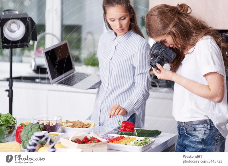 Woman photographing food in kitchen computers Laptop Computer Laptop Computers laptops notebook cameras domestic kitchen kitchens human human being human beings
