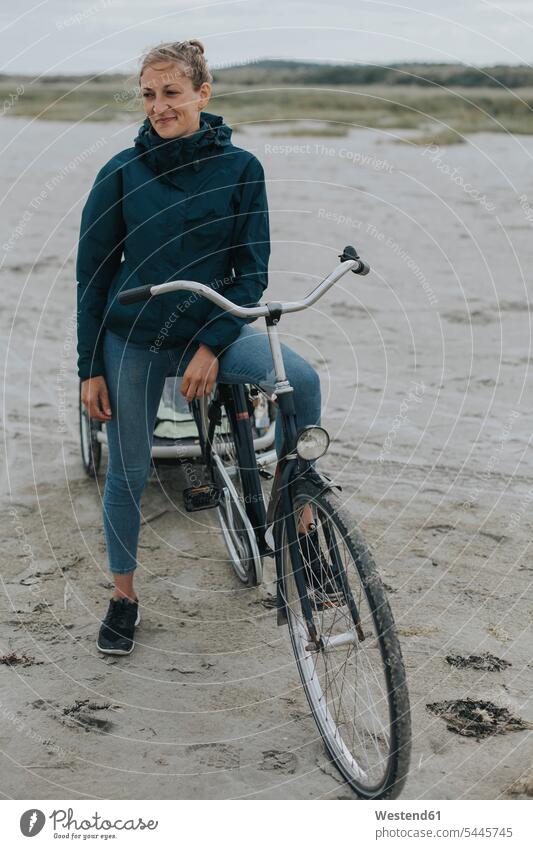 Netherlands, Schiermonnikoog, woman with bicycle and trailer on the beach beaches bikes bicycles females women Adults grown-ups grownups adult people persons